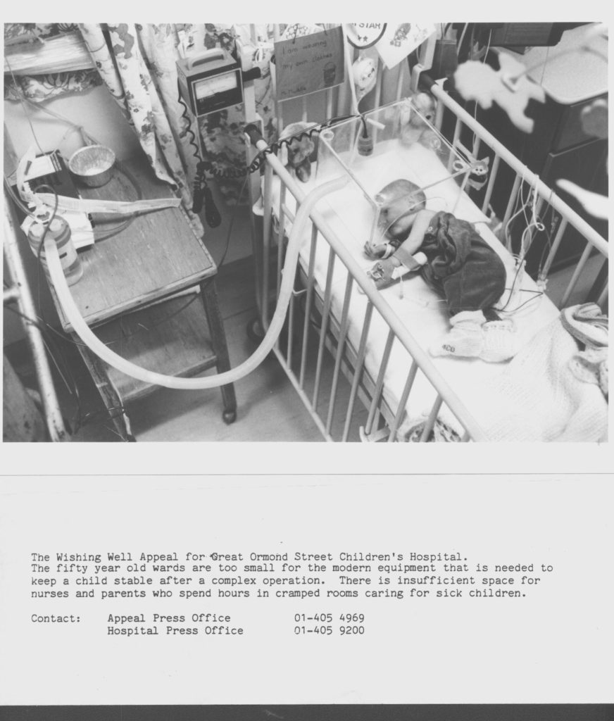 Reproduction of a captioned photograph used during the Wishing Well Appeal. The top two thirds of the page is a black and white photograph of a baby lying in a hospital crib. The baby's arm is in a brace. Over the baby's head is a ventilator. There are various other tubes and cables connected to the baby. In the bottom third of the page there is black text on a white background. The text reads "The Wishing Well Appeal for Great Ormond Street Children's Hospital. The fifty year old wards are too small for the modern equipment that is needed to keep a child stable after a complex operation. There is insufficient space for nurses and parents who spend hours in cramped rooms caring for sick children." The text ends with contact details for the hospital press office and the appeal press office.