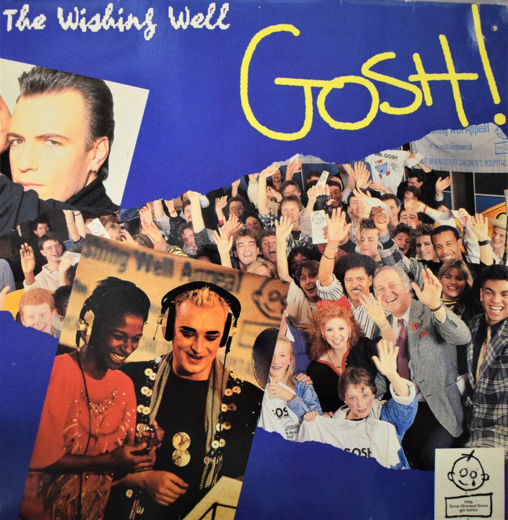A photograph of an album cover of The Wishing Well song. The cover includes the text: "The Wishing Well" and "GOSH!". There are also photographs of some of the singers involved in the appeal: Peter Cox (top left), Grace Kennedy and Boy George (bottom left). On the right there is a photo of actress and singer Bonnie Langford with a group of children and adults waving to the camera and holding t-shirts with the word GOSH written on them and leaflets with the GOSH logo. The logo is the drawing of a child's face with a teardrop coming from on eye.