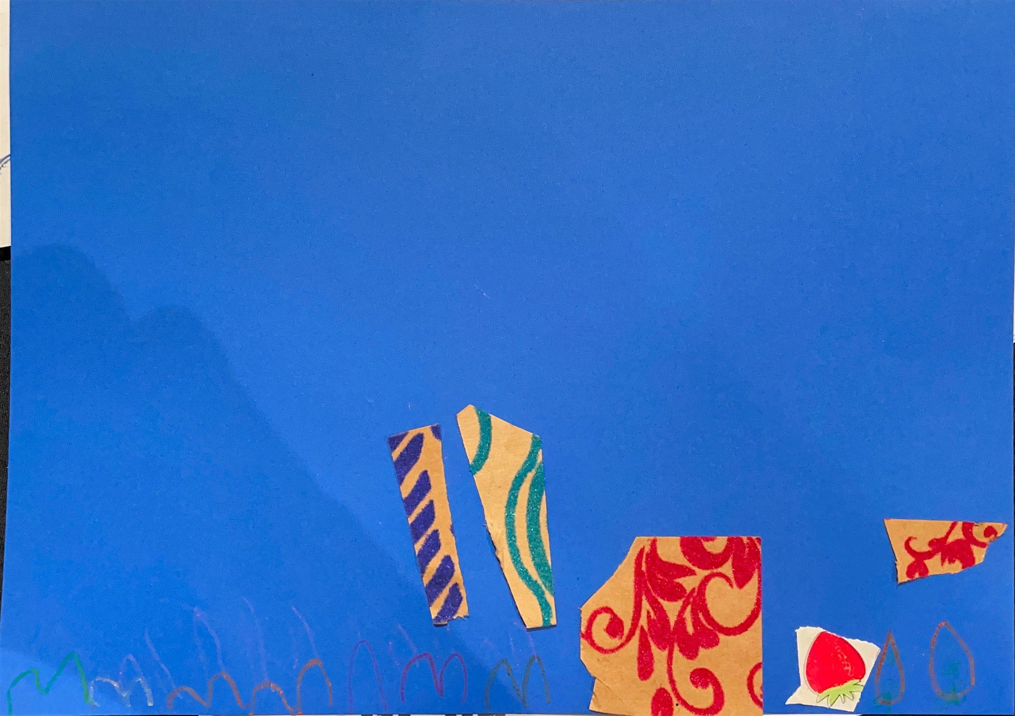 A poster by a 4-year-old Eve with pieces of patterned paper glued to a blue background.