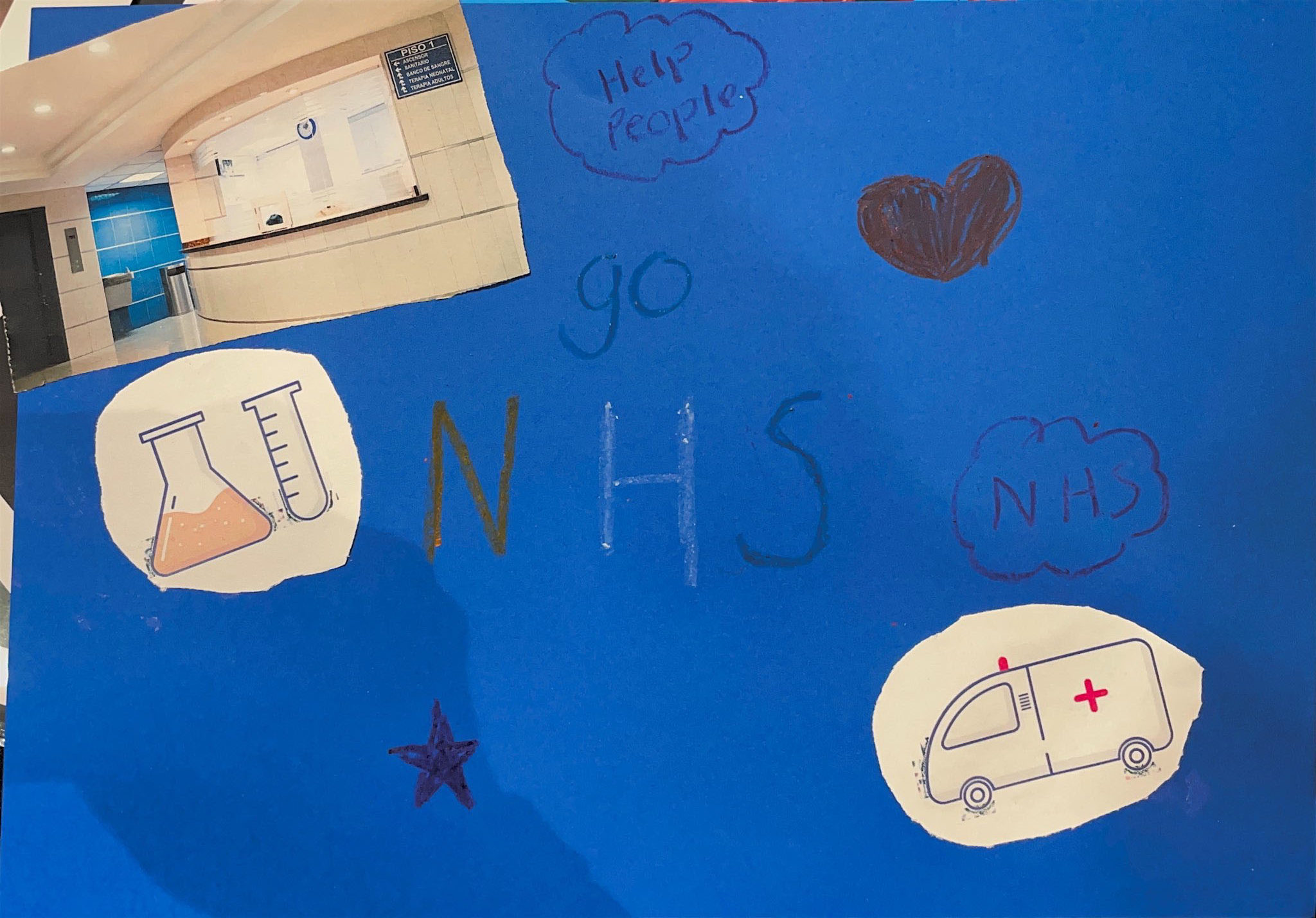 A poster with a blue background featuring a picture of a hospital reception area at the top left. Below is an illustration of a beaker and test tube. The text "Go NHS" is written in the centre in colourful letters. To the right are speech bubbles containing the words "Help People" and "NHS," along with a heart drawing. At the bottom right, there's an illustration of an ambulance, and a purple star is drawn towards the bottom left.
