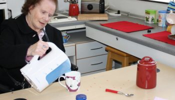 Photo of a stroke patient using adapted kettle