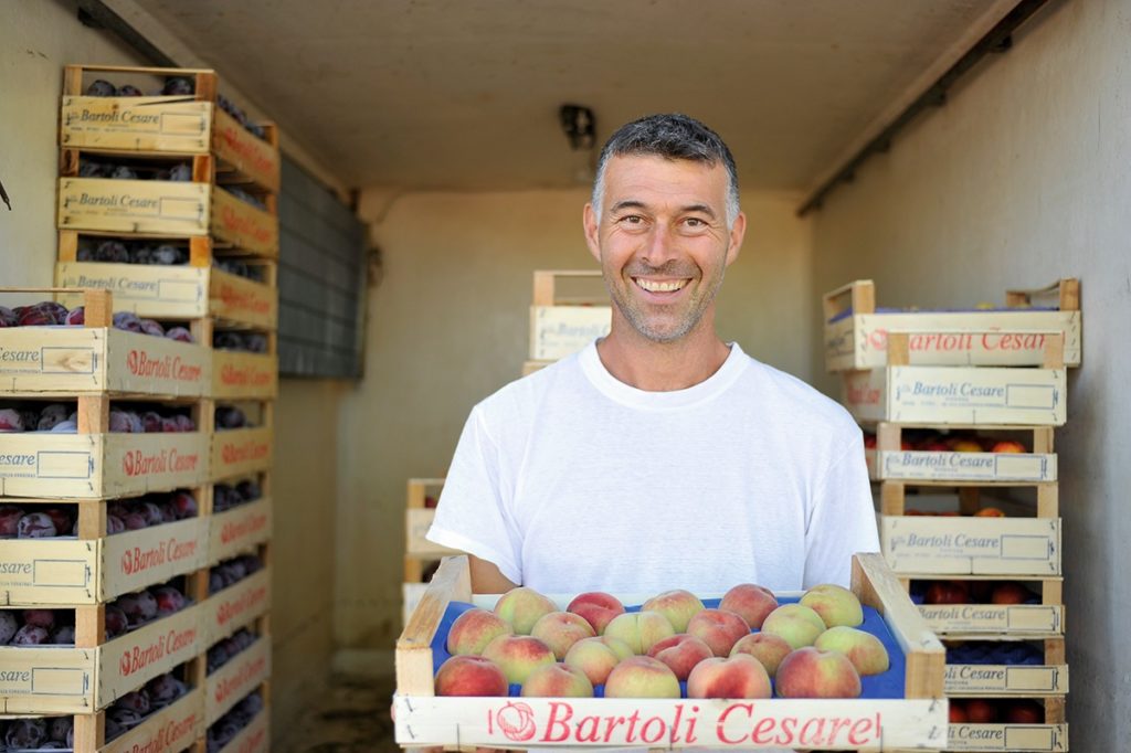 Man carrying a tray of peaches