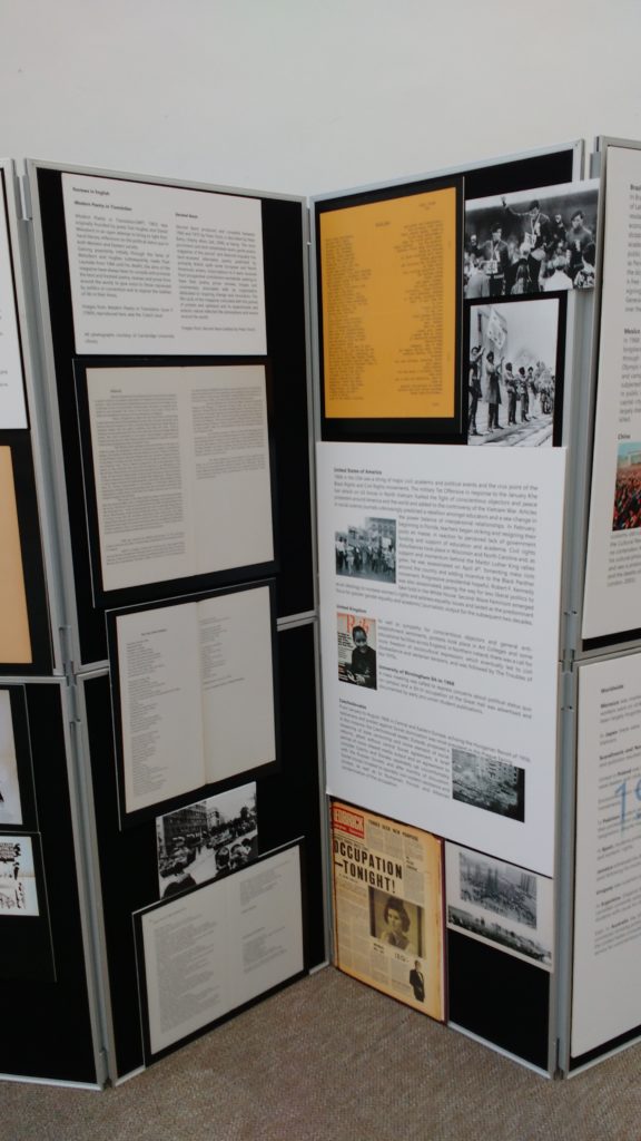 Vertical display board showing black and white photographs and texts
