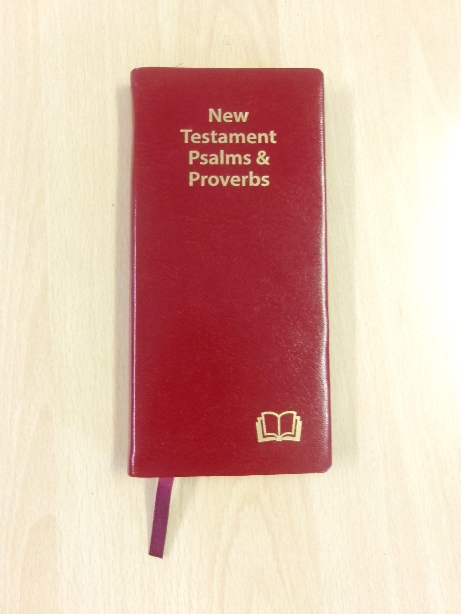 An image of a New Testament Psalms and Proverbs book on a classroom desk.